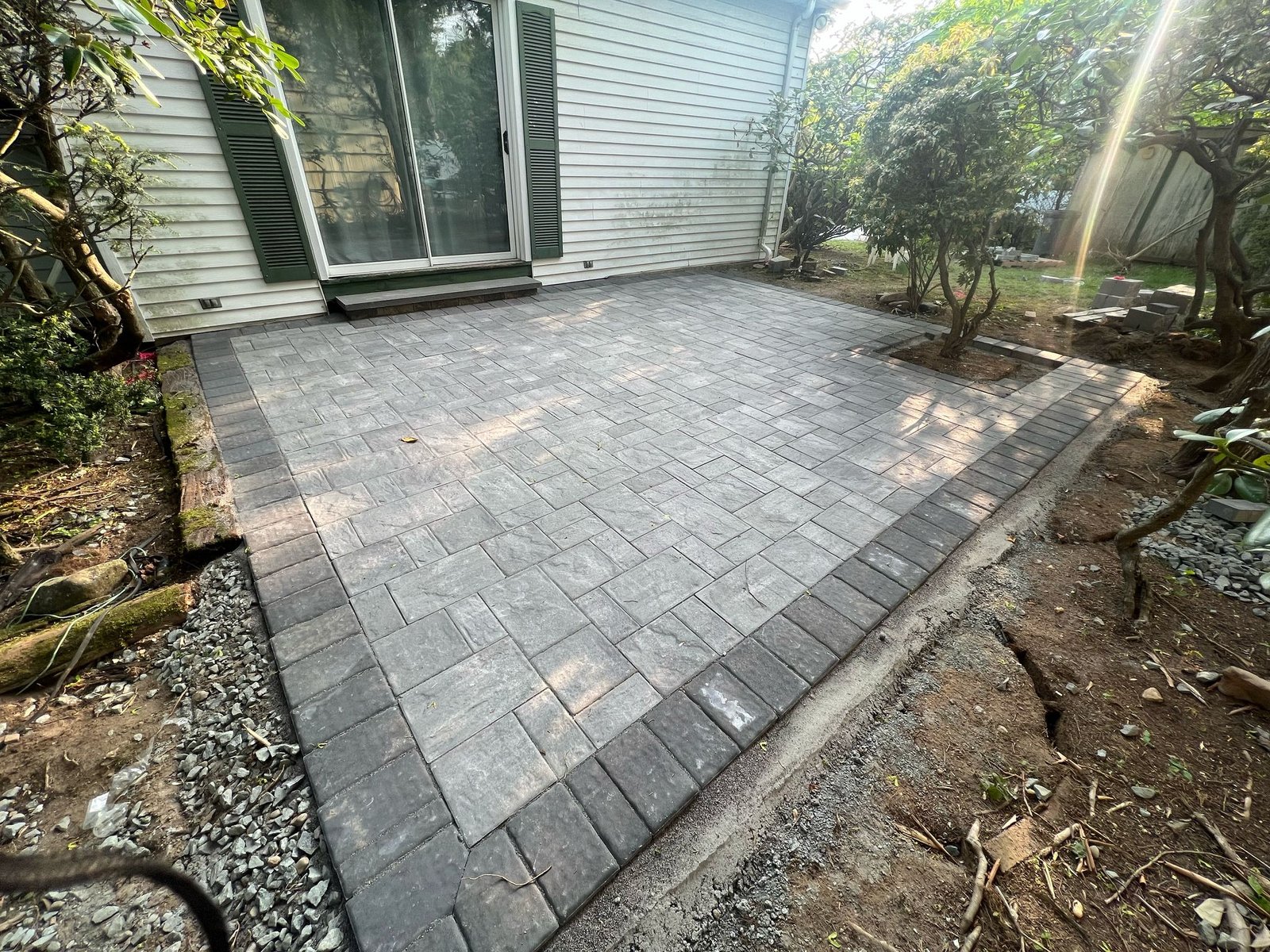 Finished charcoal paver patio adjoining white house