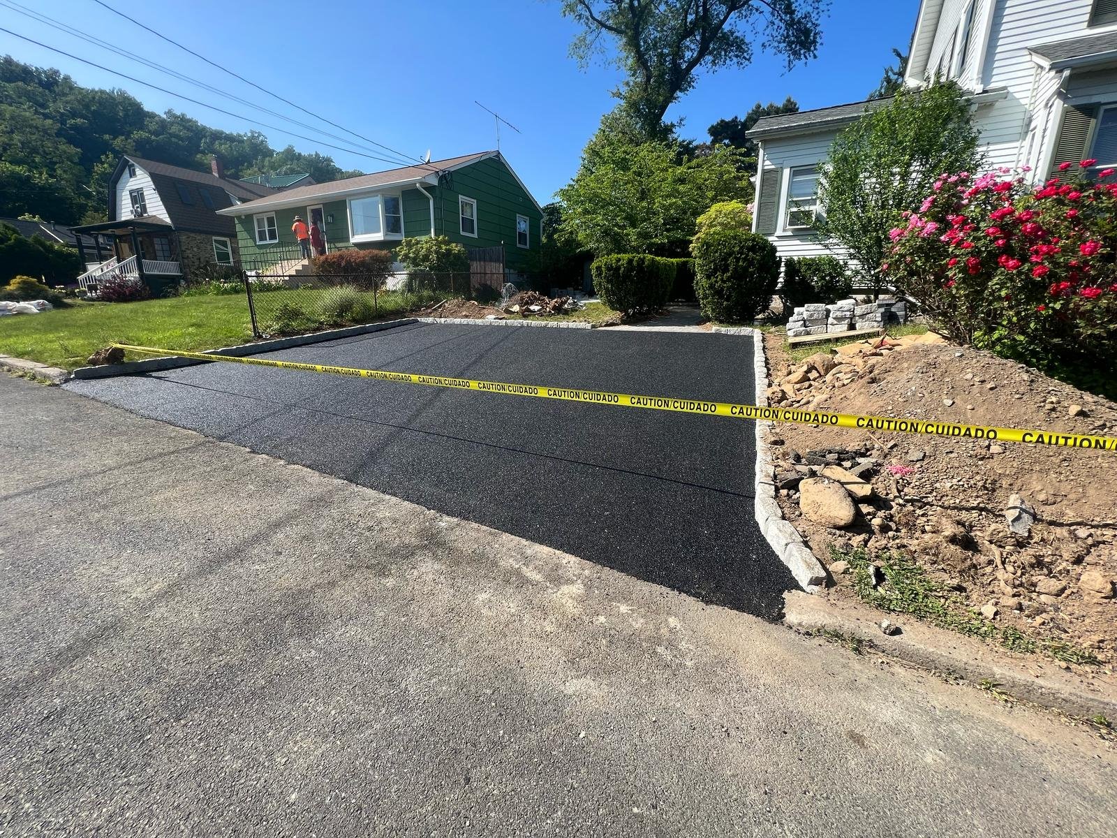 New black asphalt driveway roped off with caution tape