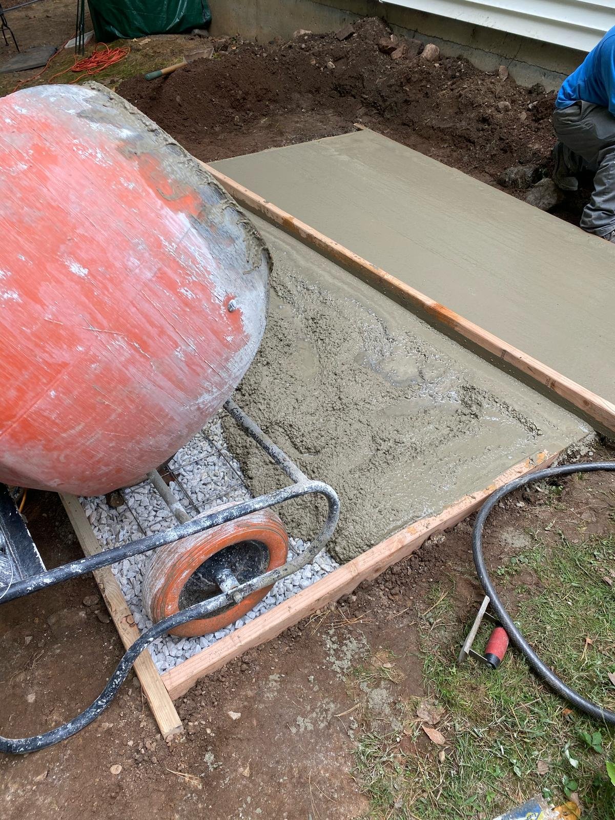 Fresh concrete being poured from mixer into form
