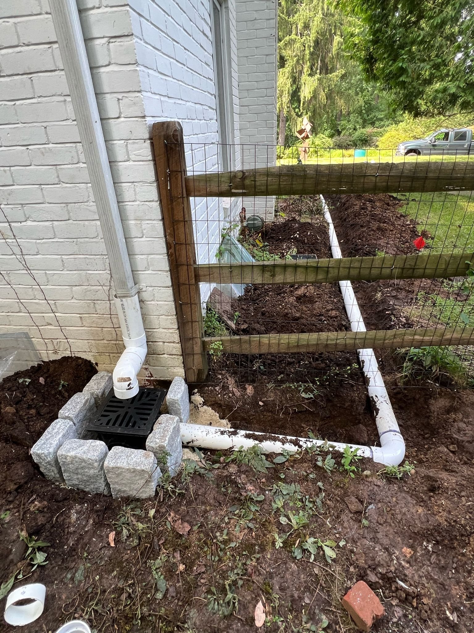 Catch basin tied to PVC outlet running along foundation